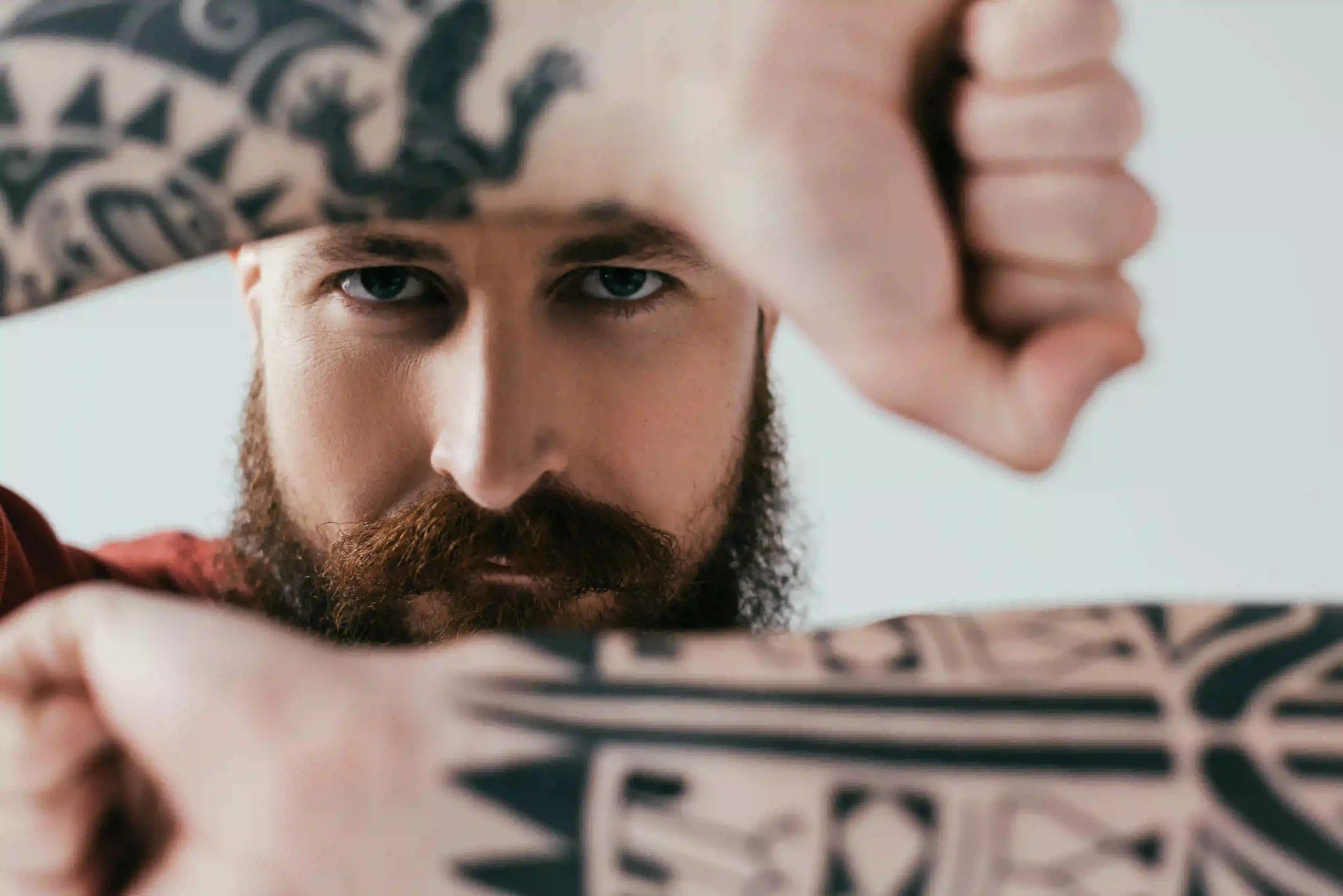 bearded tattooed man showing block gesture isolate.