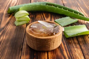 A cut of the pulp of aloe vera in a woden bowl for aloe vera tattoo removal.