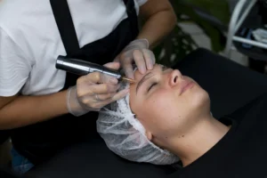 Beautician doing tattoo removal procedure.