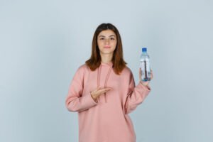 A young lady holding a bottle of water.