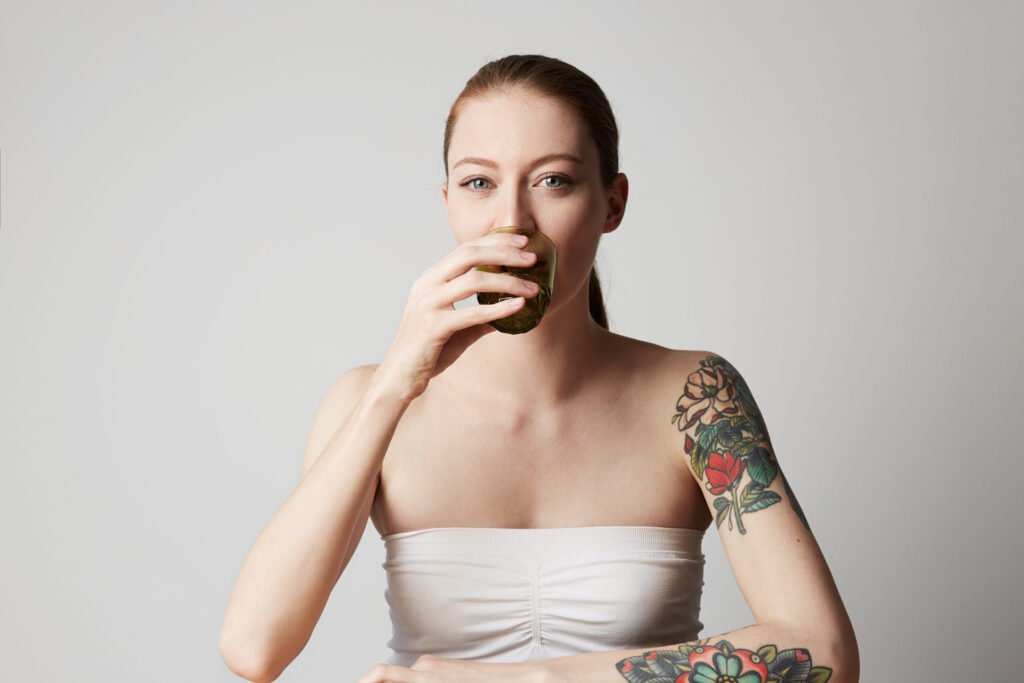 A tattooed women drinking tea