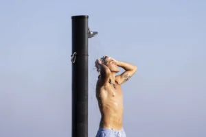 Man taking shower outside side view.